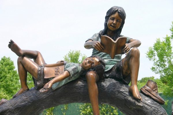 Boy and Girl Reading On A Tree Branch