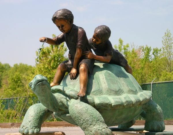 Two Boys Riding A Turtle